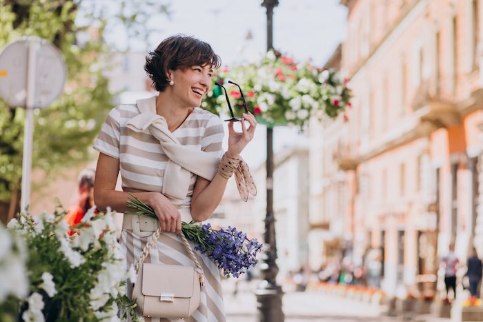 Young woman with flowers walking in town immersive French course in Paris